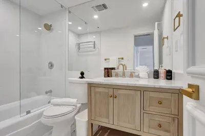 a white bathroom with a toilet and a sink at Luxury 2BD Penthouse with Beach Access and Resort Amenities PH6 in Miami Beach
