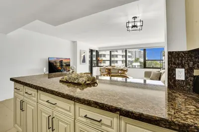a kitchen with a counter top and a living room at Beautiful Oceanview Condo with Beach Service 504 in Miami Beach