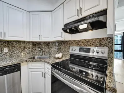 a kitchen with white cabinets and a stove top oven at Beautiful Oceanview Condo 2 Bedrooms, 2 Bathrooms with Beach Service 709 in Miami Beach