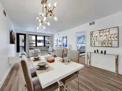 a dining room and living room with a white table and chairs at Luxury Beach Condo with Exclusive Resort Amenities 1016 in Miami Beach