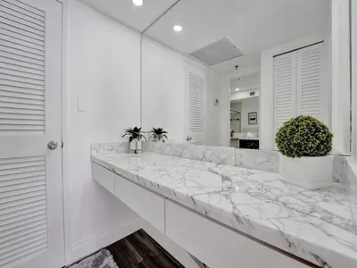a white kitchen with a marble counter top at Luxury Beach Condo with Exclusive Resort Amenities 1016 in Miami Beach