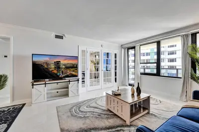 a living room with a blue couch and a tv at Comfortable 2-Bedroom Condo Retreat with Resort Facilities 1108 in Miami Beach