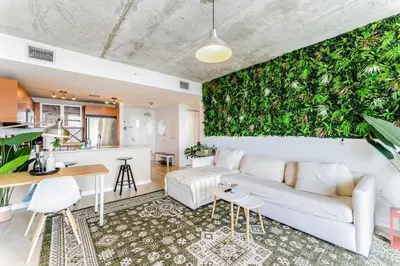 a living room with a white couch and a green wall at 1BR Miami Retreat with BBQ, Pool, & Skyline Views in Miami