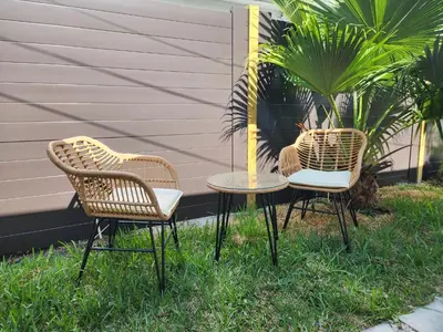 three rattan chairs and a table in the grass at 2-bed Lakeridge Fllfree Parking 6 Min To Beach in Fort Lauderdale