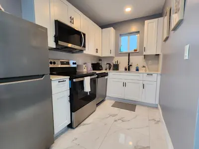 a kitchen with white cabinets and black appliances at 2-bed Lakeridge Fllfree Parking 6 Min To Beach in Fort Lauderdale