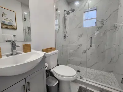 a bathroom with a toilet and a sink and a shower at 2-bed Lakeridge Fllfree Parking 6 Min To Beach in Fort Lauderdale