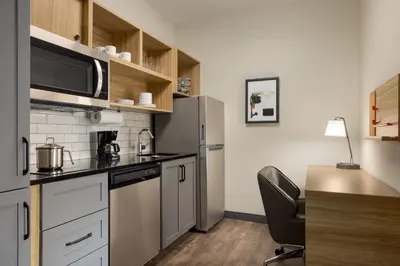 a small kitchen with a refrigerator and a chair in it at Candlewood Suites Miami - Doral by IHG in Tamiami