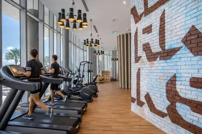 a gym with treadmills and people running on treadles at Ventur Beachfront Luxe Condo - Lyfe Beach Resort in Hollywood