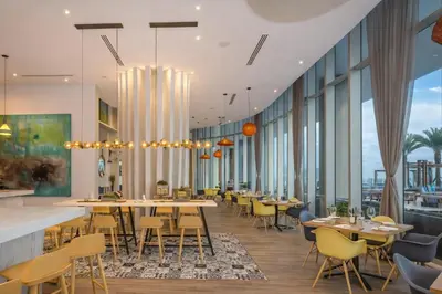 a restaurant with tables and chairs and large windows at Ventur Beachfront Luxe Condo - Lyfe Beach Resort in Hollywood