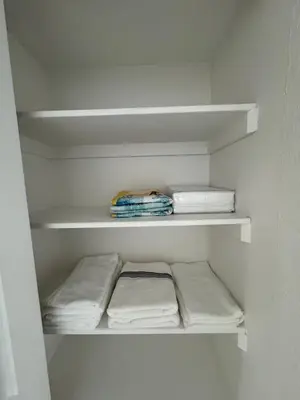 a white closet with white shelves and towels at 1 bedroom with amazing ocean view in Hollywood