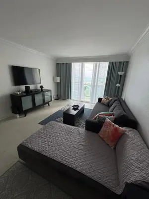 a living room with a couch and a tv at 1 bedroom with amazing ocean view in Hollywood