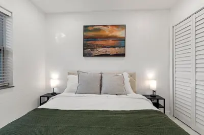 a bedroom with a bed with two lamps on tables at Yellow Door Oasis airport, cruise port and beach close-by in Fort Lauderdale