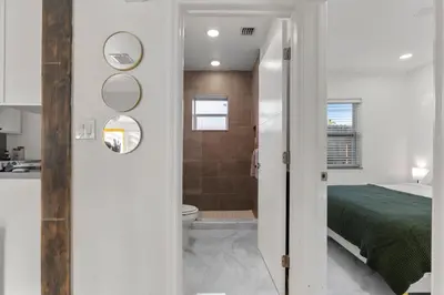 a bathroom with a toilet and a bed in a room at Yellow Door Oasis airport, cruise port and beach close-by in Fort Lauderdale