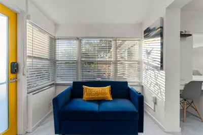 a blue couch in a room with a window at Yellow Door Oasis airport, cruise port and beach close-by in Fort Lauderdale