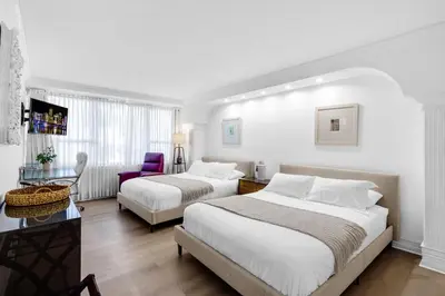 a hotel room with two beds and a purple chair at Huge Beachfront 2400sqft 5 Bedroom 5 Bathroom with Ocean View in Miami Beach