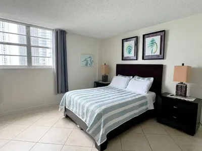 a bedroom with a bed with a striped bedspread at Spectacular ocean view 1 bedroom in Hollywood in Hollywood
