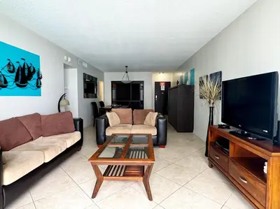 a living room with a couch and a tv at Spectacular ocean view 1 bedroom in Hollywood in Hollywood