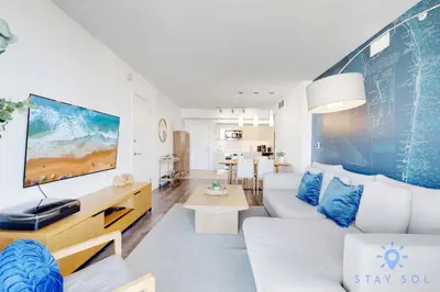 a living room with a white couch and a tv at Modern Stylish 2BR with Balcony in Hallandale Beach