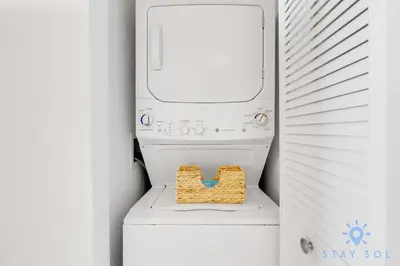 a white washer and dryer with a basket on top at Modern 1BR with Pool & Balcony in Hallandale Beach