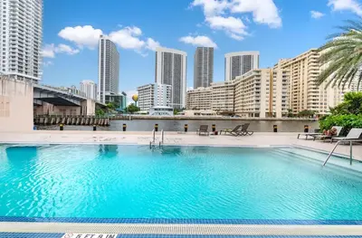 a large swimming pool with a city skyline in the background at Luxury Suite on Beachwalk with Pool Gym & Beach in Hallandale Beach