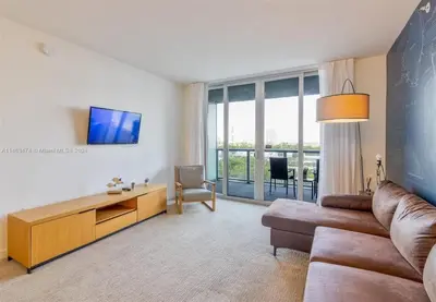 a living room with a couch and a tv at 1 Bdm & Kitchen at Beachwalk Pool Gym Beach in Hallandale Beach
