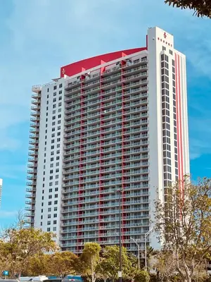 a large tall building with a red and white top at 1 Bdm & Kitchen at Beachwalk Pool Gym Beach in Hallandale Beach