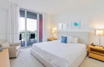 a white bedroom with a large bed and a window at 2 Bed 2 Bath at Beachwalk with Luxury Pool and Gym in Hallandale Beach