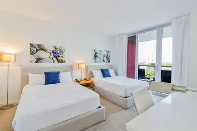 a hotel room with two beds and a window at 2 Bed 2 Bath at Beachwalk with Luxury Pool and Gym in Hallandale Beach