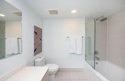 a white bathroom with a toilet and a shower at Modern 1BR w- Kitchen on 30th Floor Epic Views in Hallandale Beach