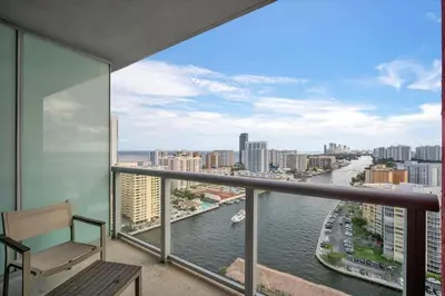 a balcony with a bench and a view of the water at Luxury 2BR-2BA Condo on 30th Floor with Epic Views in Hallandale Beach
