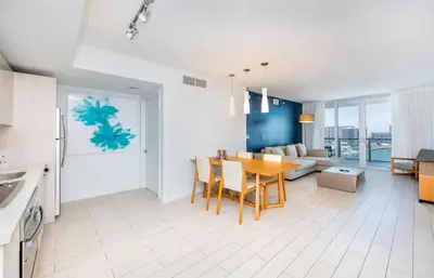 a kitchen and living room with a table and a couch at Luxury 2BR-2BA Condo on 30th Floor with Epic Views in Hallandale Beach