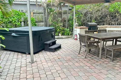 a patio with a hot tub and a table and chairs at One - BR spacious beach place in Hollywood