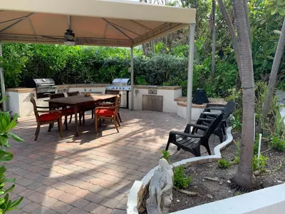 a patio with a table and chairs under an umbrella at One - BR spacious beach place in Hollywood