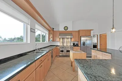 a large kitchen with wooden cabinets and stainless steel appliances at One - BR spacious beach place in Hollywood