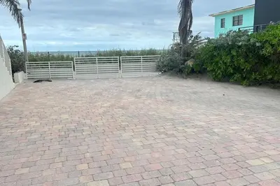 a brick driveway with a white fence in front of a house at Oceanfront Villa On Semi-Private Holywood Beach in Hollywood