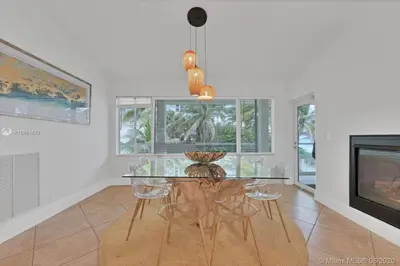 a dining room with a glass table and chairs at Oceanfront Villa On Semi-Private Holywood Beach in Hollywood