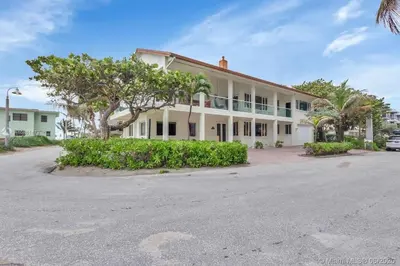 a large white building with trees in front of it at Oceanfront Villa On Semi-Private Holywood Beach in Hollywood