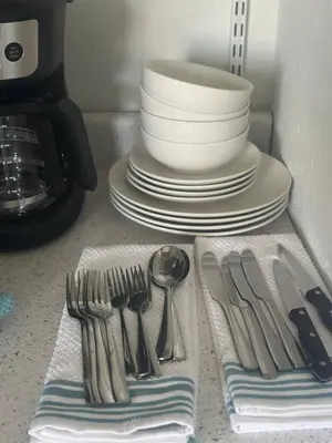 a kitchen counter with plates and forks and spoons at Cozy studio in Hollywood, FL in Hollywood