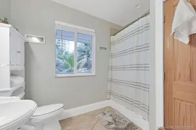 a bathroom with a toilet and a sink and a window at Gorgeous 4-bedroom beach space in Hollywood