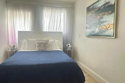 a bedroom with a large bed with a blue blanket at Gorgeous 4-bedroom beach space in Hollywood