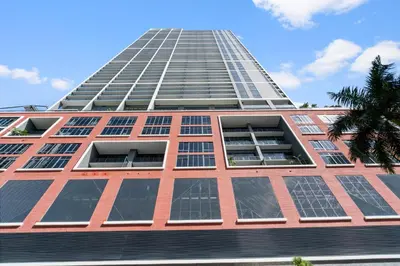a tall building with lots of windows and a palm tree at Suite at downtown Miami residences - Great view 30th floor in Miami