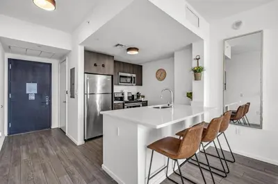a kitchen with a large white counter and chairs at Experience Miami Modern 2 Bed Near Biscayne Blvd in Miami