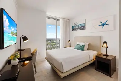 a white bedroom with a bed and a large window at 42nd Floor Penthouse 3 BDR in Hyde Beach House in Hollywood