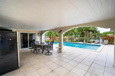 a patio with a table and chairs and a pool at The Aqua Villa in Hollywood