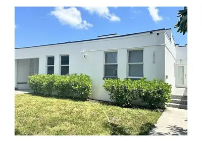 a white house with bushes in front of it at 2bed Stay in the Heart of Miami in Miami
