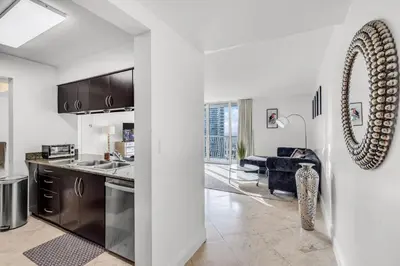 a kitchen with a sink and a living room at Best views, 2 balconies, 2 bedrooms, pool, gym, parking in Miami
