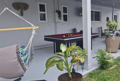 a patio with a hammock and a pool table at Luxury 3BR Duplex in Cutler Bay, Pool Table, BBQ, Terrace & Free Parking in Cutler Ridge