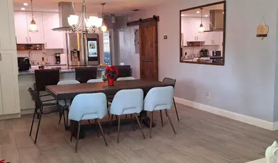 a dining room with a table and white chairs at Luxury 3BR Duplex in Cutler Bay, Pool Table, BBQ, Terrace & Free Parking in Cutler Ridge