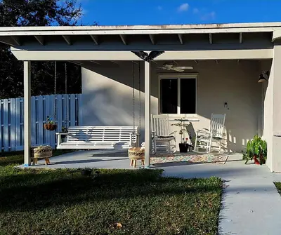 a patio with awning and chairs on a house at Luxury 3BR Duplex in Cutler Bay, Pool Table, BBQ, Terrace & Free Parking in Cutler Ridge