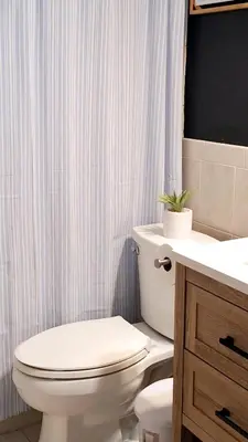 a bathroom with a white toilet and a sink at Luxury 3BR Duplex in Cutler Bay, Pool Table, BBQ, Terrace & Free Parking in Cutler Ridge